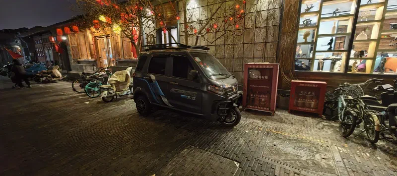 Электромобиль 大江 на фоне фонариков в хутуне